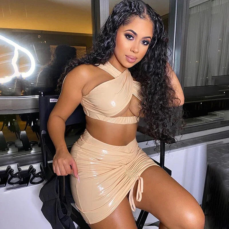Ensemble clubwear vinyle noir avec mini-jupe plissée et crop top croisé